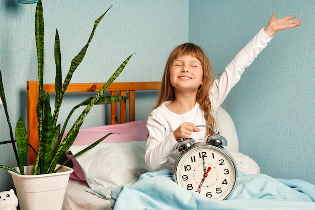 Petite fille s'est réveillée de bonne humeur en s'étirant j'ai bien dormi il est temps de se lever et bonjour en bonne santé