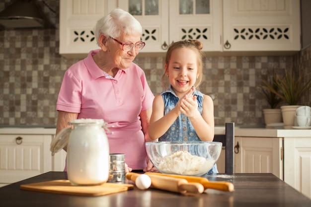 Petite fille et sa grand-mère cuisiner dans la cuisine