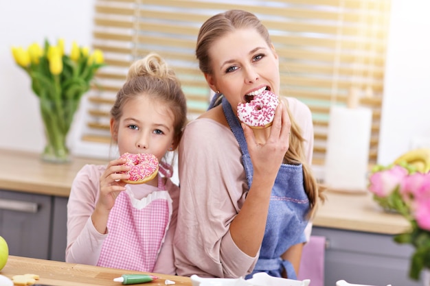 petite fille et sa maman en tablier s'amusant dans la cuisine