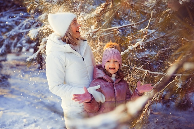 Petite fille et sa mère jouant dehors pendant la journée ensoleillée d'hiver