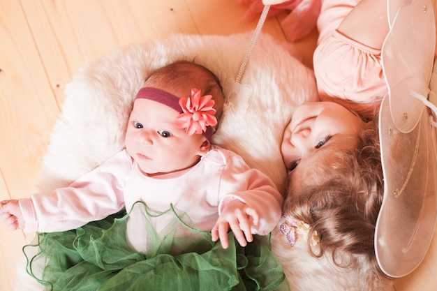 Petite fille avec sa soeur nouveau-née dans un panier