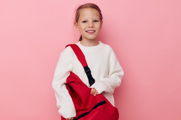 Petite fille avec un sac à dos rouge amusant fond isolé