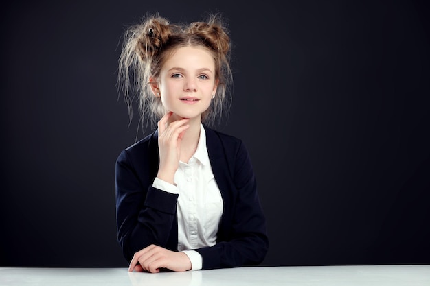 Petite fille avec sac d'école près du tableau noir dans la salle de classe