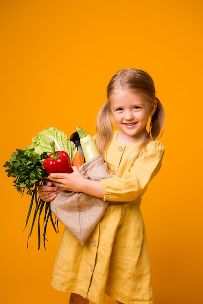 petite fille avec un sac écologique et des légumes