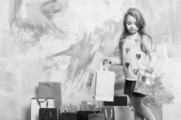 Petite fille avec sac à provisions Célébration des fêtes et fête Noël et anniversaire Enfant fille avec pack cadeau sur fond coloré Enfance et bonheur espace de copie