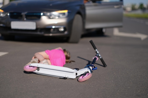 Petite fille en scooter frappée sur la route par un accident de la route automobile