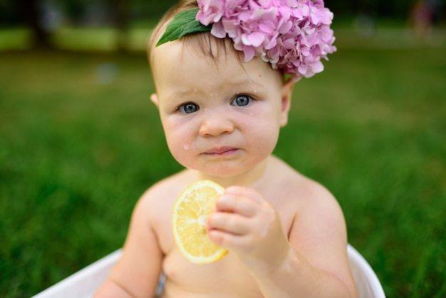 Petite fille se baigne dans un bain de lait dans le parc. La fille s'amuse en été.