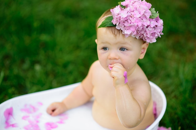 Petite fille se baigne dans un bain de lait dans le parc