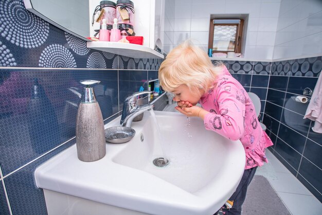 petite fille se brosse les dents dans la salle de bain