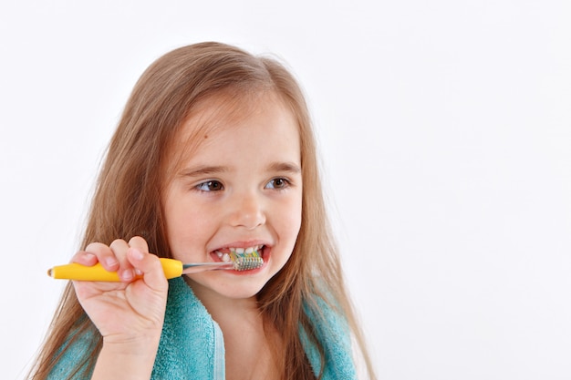 Une petite fille se brosse les dents