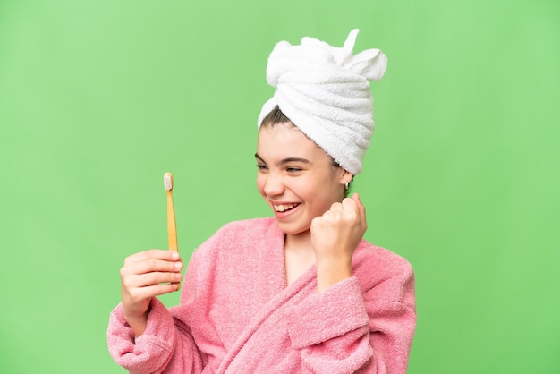 Petite fille se brosser les dents sur fond isolé chroma key célébrant une victoire