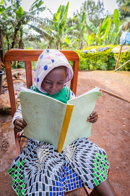 Une petite fille se concentre sur la lecture des notes de son cahier d'école Concept d'éducation en Afrique