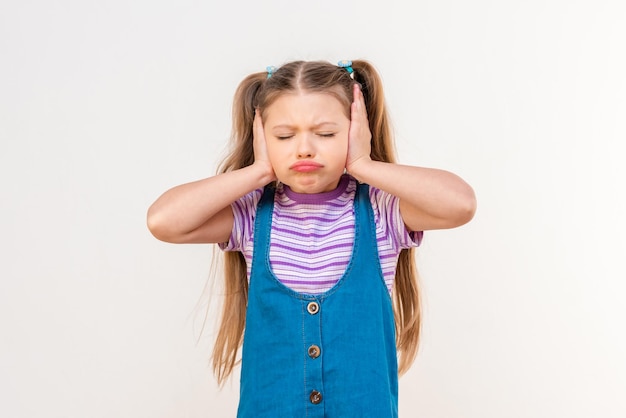 La petite fille se couvrit les oreilles avec ses paumes.