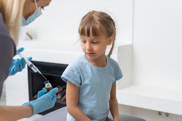 Petite fille se faisant vacciner par un pédiatre au cabinet médical.