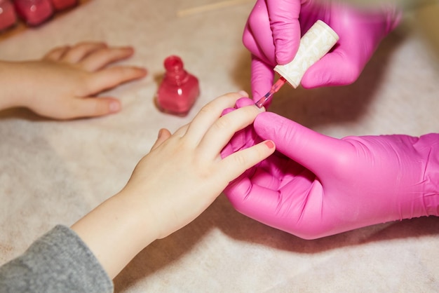 Petite fille se fait manucurer dans un salon de beauté agrandi