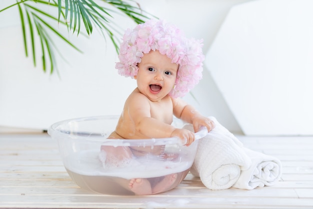 petite fille se lave dans un bassin avec de la mousse