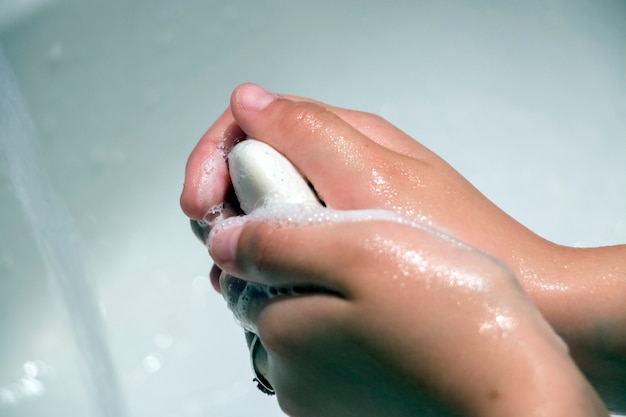 Petite fille se laver les mains dans la salle de bain