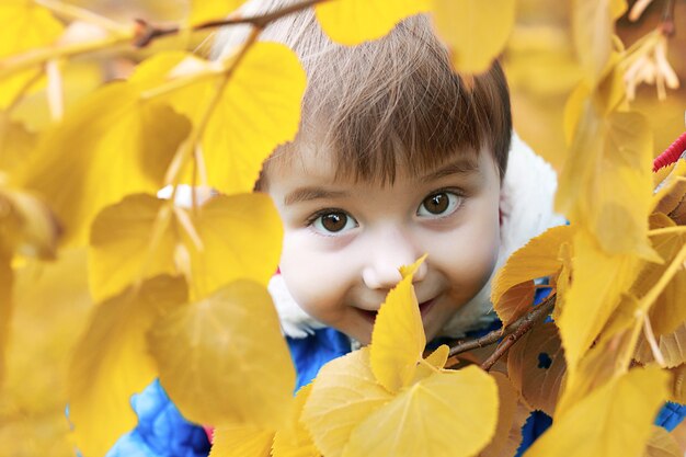 Petite fille se présentant à la caméra marchant dans le parc en automne