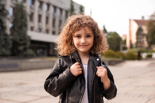 La petite fille se promène dans la ville avec un sac