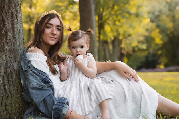 Une petite fille se promène avec sa mère à l'extérieur.