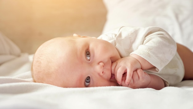 Petite fille se trouve sur le ventre sur le lit des parents