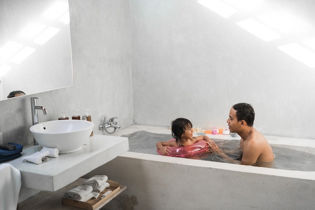 Petite fille avec son père prendre un bain ensemble