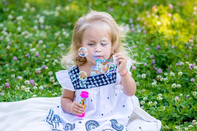 Photo petite fille soufflant des bulles dans le parc