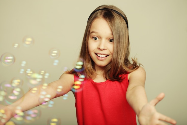 petite fille soufflant des bulles de savon