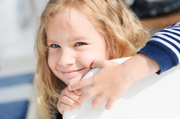 Petite fille souriante de 3 à 4 ans avec de longs cheveux blonds en plein air. Saison des vacances d'été.