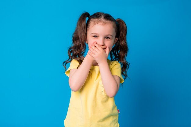 petite fille souriante sur bleu