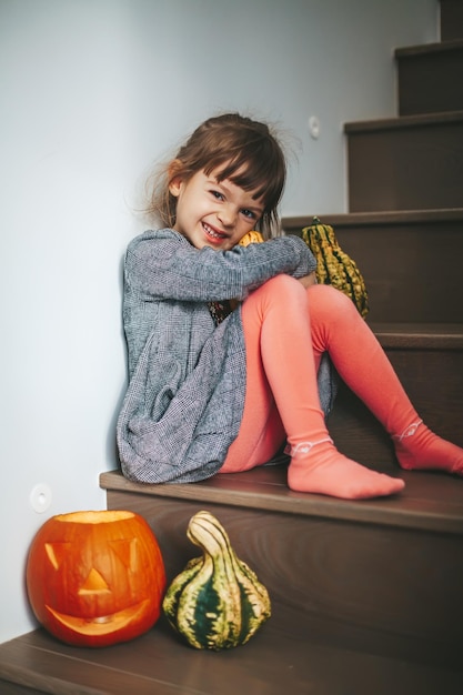 Petite fille souriante avec la citrouille d'Halloween