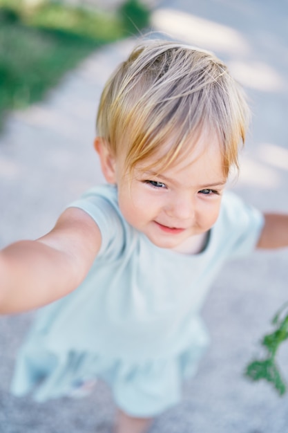 Petite fille souriante dans une robe dans la vue sur le parc d'en haut portrait