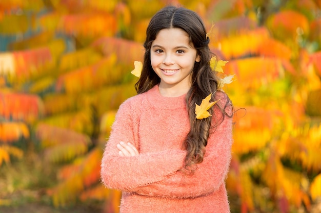 Petite fille souriante enfant heureux magnifique cheveux longs feuilles d'érable. Journée d'automne confortable. Kid profiter de l'automne à l'extérieur. Rencontrez l'automne. Protégez vos cheveux tout au long de la journée contre d'autres dommages environnementaux.