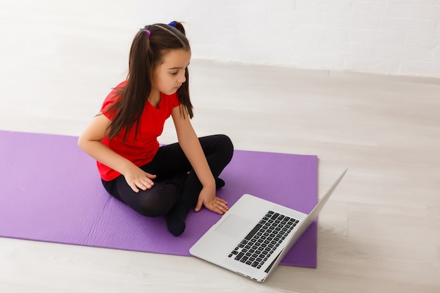 petite fille souriante faisant des exercices à la maison