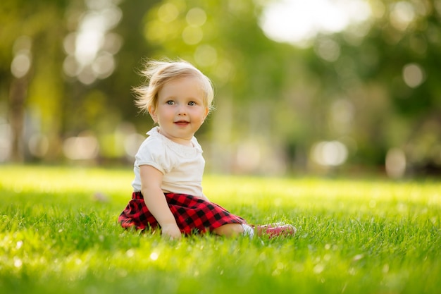 petite fille souriante sur l'herbe verte