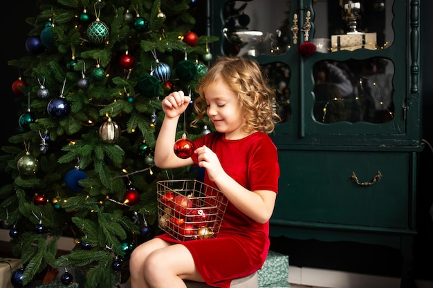 Petite fille souriante jouant avec la décoration de Noël Coffrets cadeaux de Noël sur fond