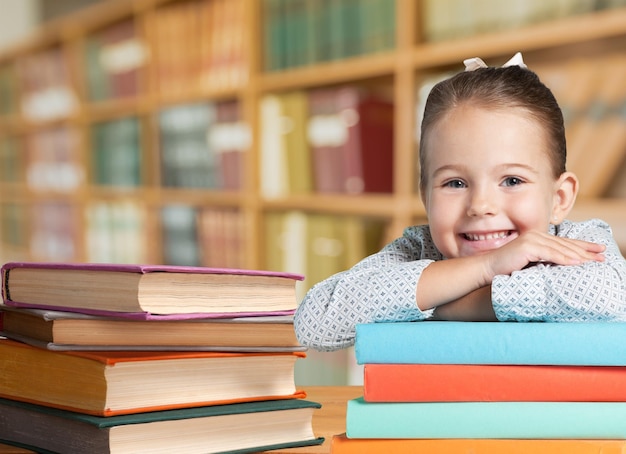Une petite fille souriante avec des livres