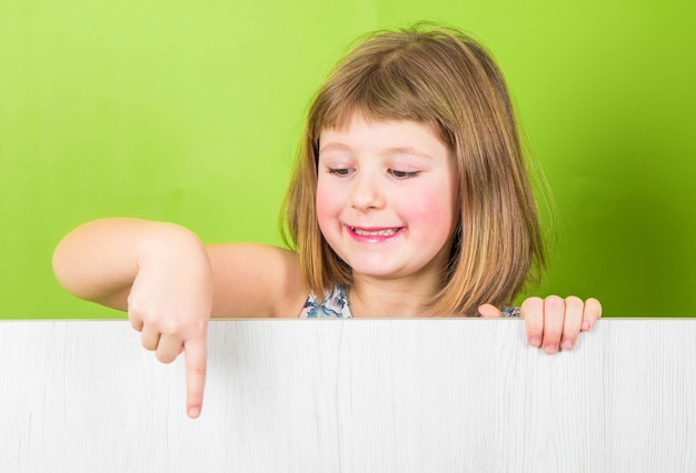 Petite fille souriante avec panneau blanc