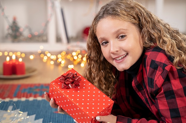 La petite fille sourit heureuse pour Noël à la maison