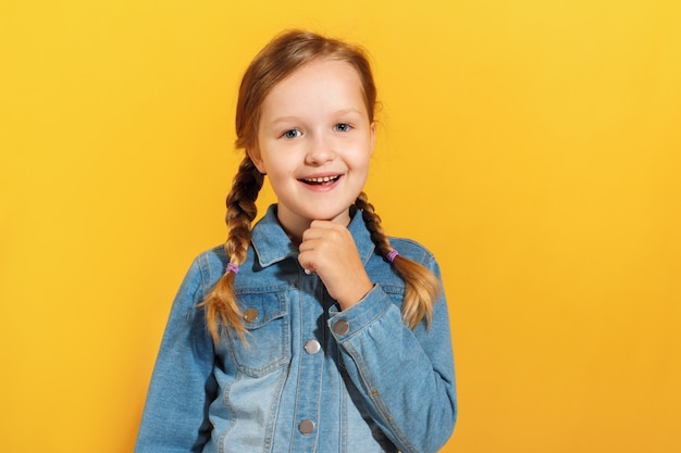 Petite fille sourit et regarde la caméra