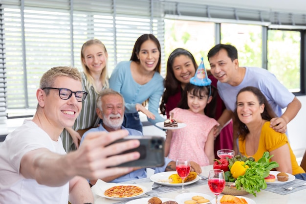 Petite-fille surprise avec un gâteau au chocolat pour une fête d'anniversaire en famille après le dîner à la maison