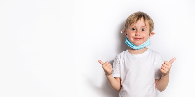 Petite fille en t-shirt blanc et masque médical jouant au docteur