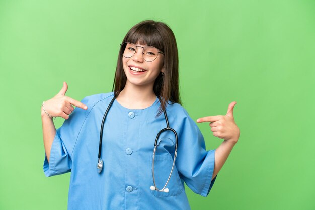 Petite fille en tant que médecin chirurgien sur fond isolé chroma key fier et satisfait de soi