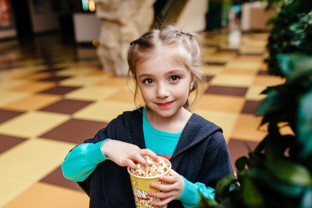 Petite fille avec une tasse de pop-corn dans le parc