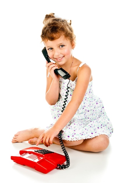 Petite fille avec téléphone isolé sur fond blanc