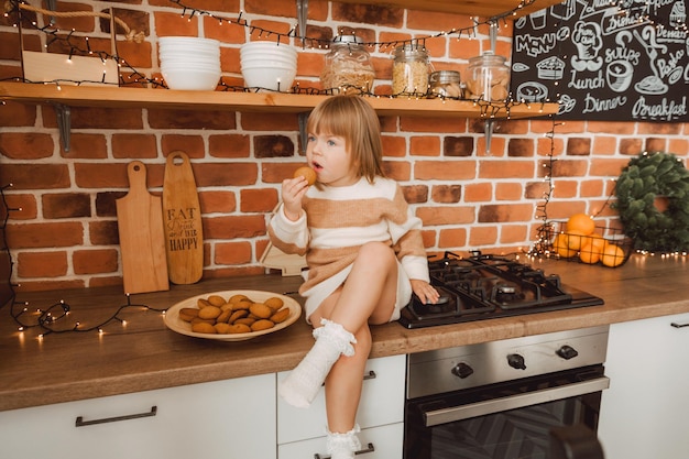 Petite fille tenant une assiette en forme de chevron. il y a des cookies dans l'assiette.