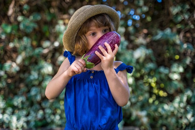 Petite fille tenant une aubergine écologique