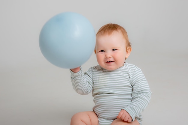 Petite fille tenant un ballon bleu