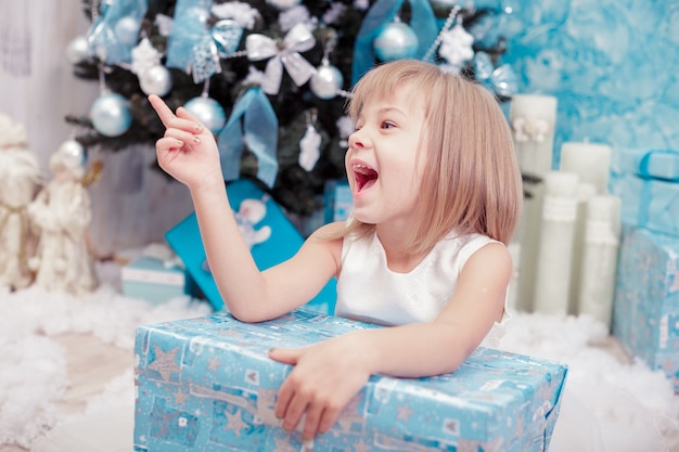 Petite fille tenant une boîte cadeau magique de Noël