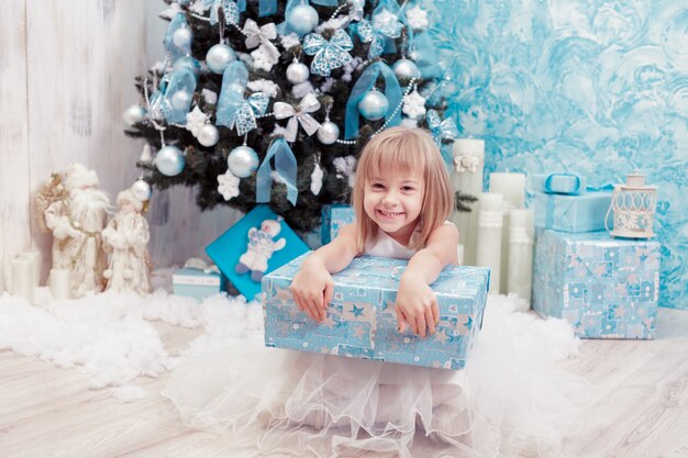 Petite fille tenant une boîte cadeau magique de Noël